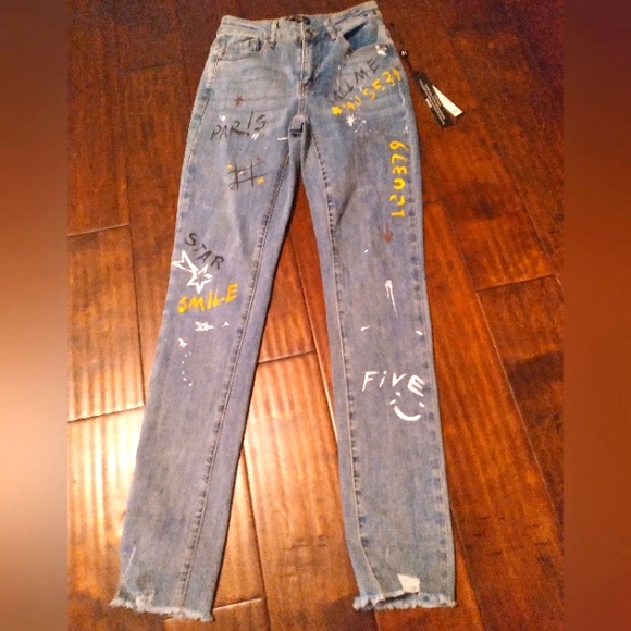 Trendy Distressed Light Wash Denim Jeans with Custom Graffiti Art and Raw Hem‎